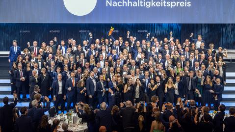 Die Gewinner*innen des Deutschen Nachhaltigkeitspreises 2023 jubeln mit den Trophäen auf der Bühne