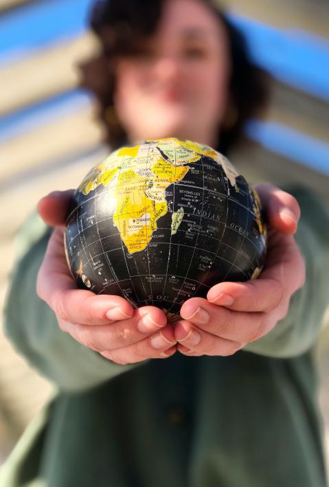 A globe in the hand of a woman. 