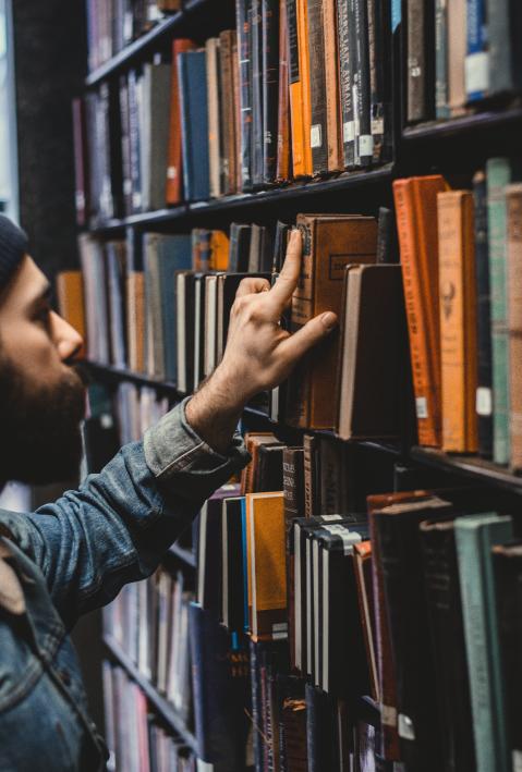 Man picking book in library.