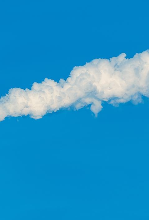 Smoking chimney against blue sky. 