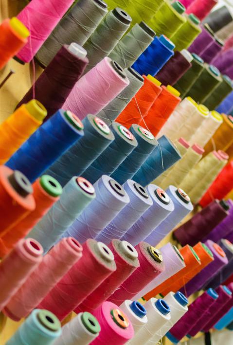 Colorful thread spools used in fabric and textile industry. The concept of sewing production