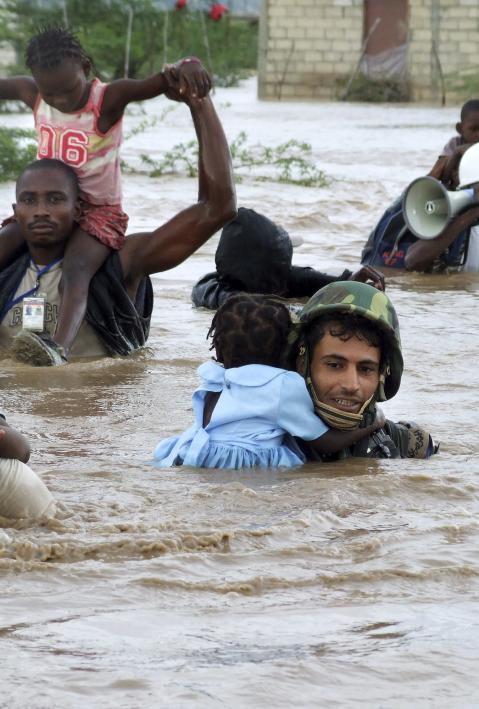 Jordanian UN peacekeepers rescue children from an flooded orphanage some 20 kilometres north of Port au Prince after the passing of hurricane Ike
