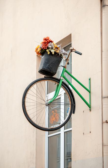 Installation mit Fahrradvorderteil und Blumenkörbchen an Fahrradwerkstatt 